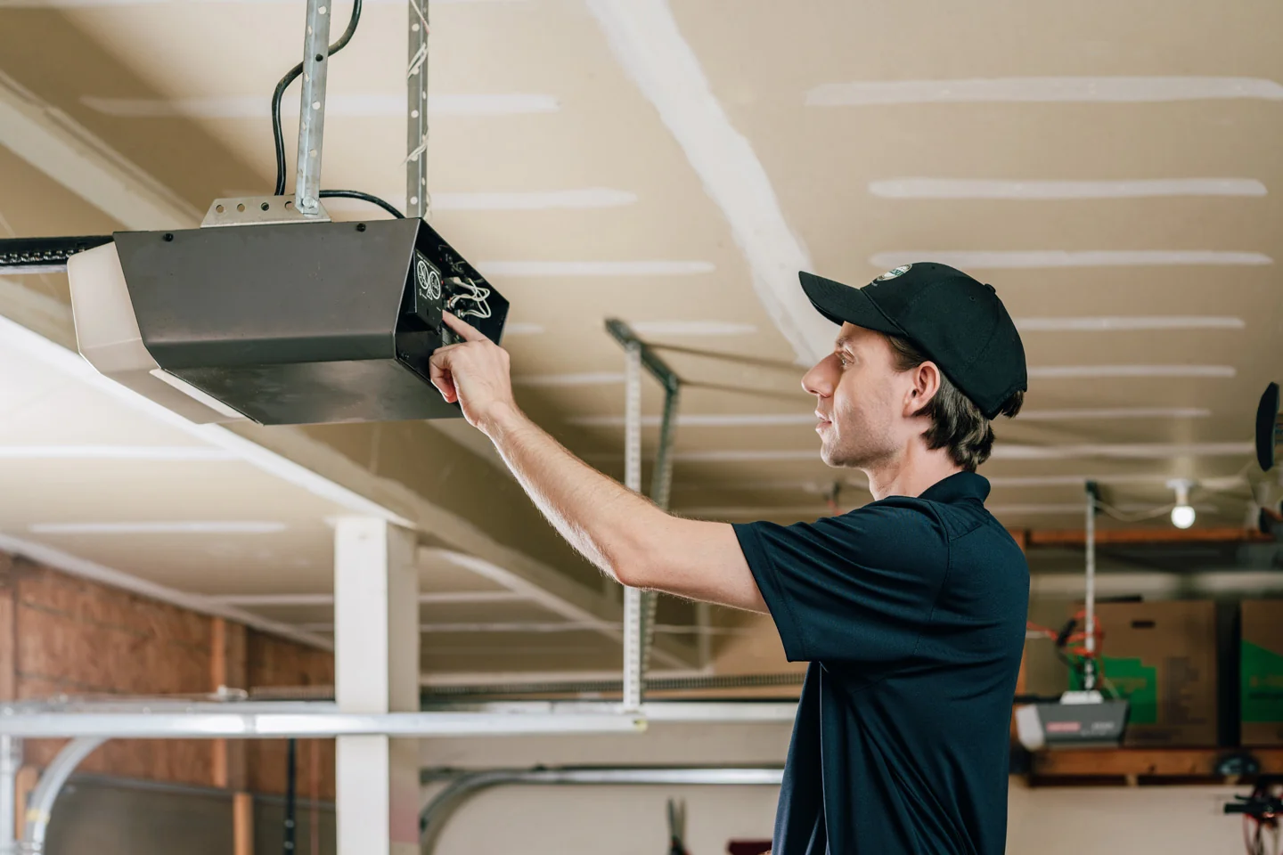 Precision Garage Door technician fixing an opener
