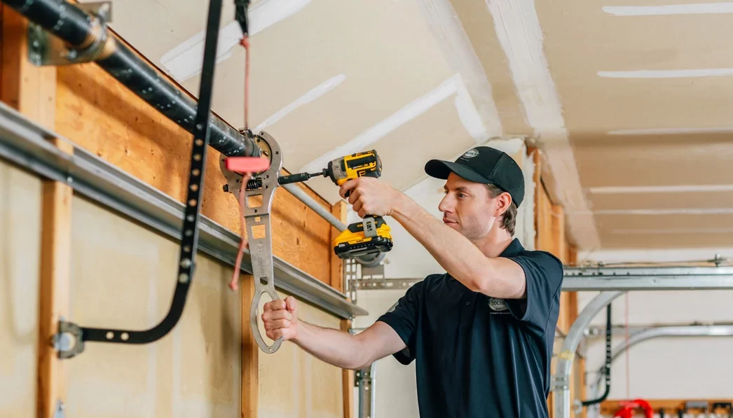 Precision Garage Door technician repairing a spring